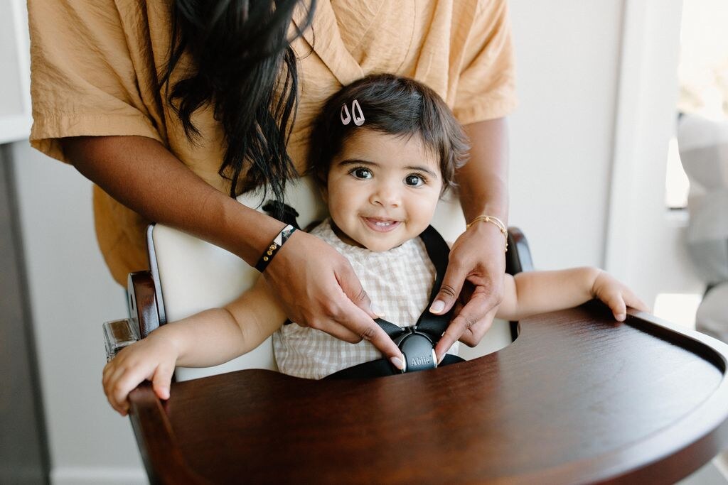 Baby being strapped into a high chair
