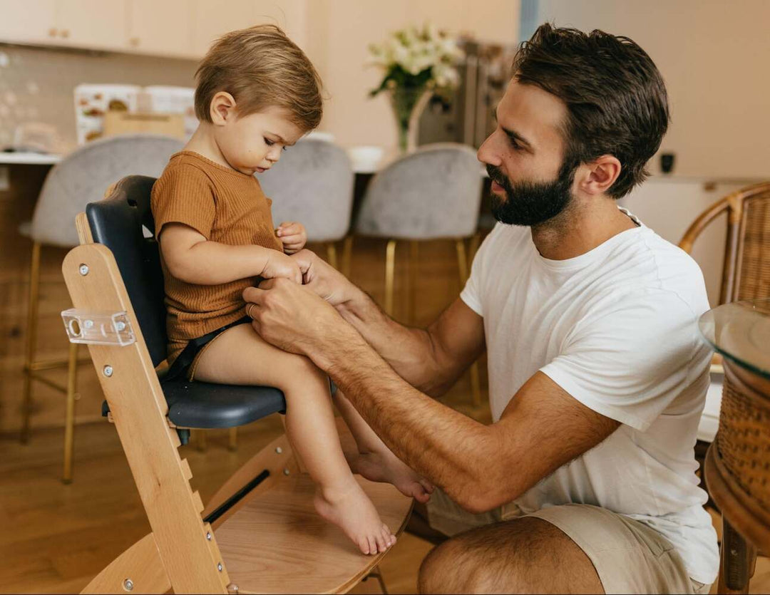 Father helping child in high chair