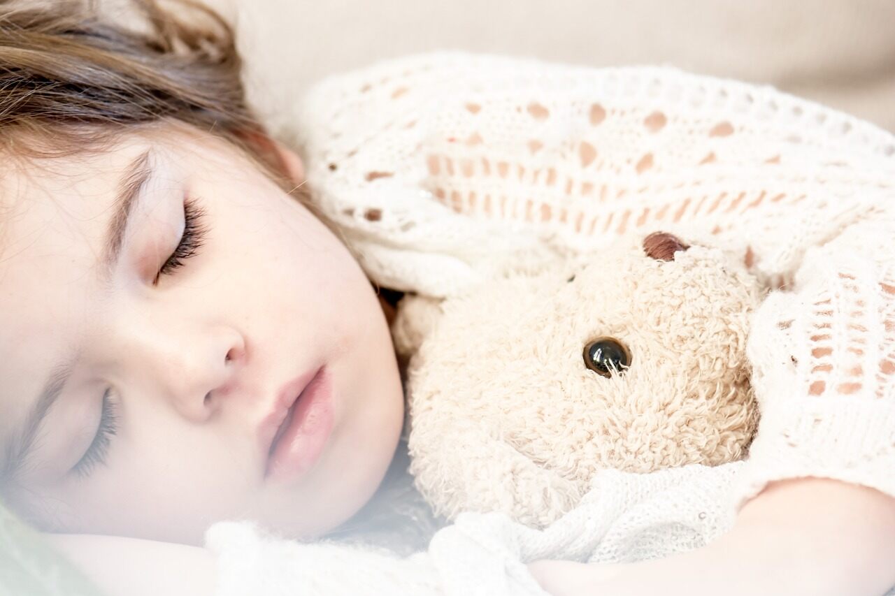 baby girl sleeping with stuffed animal