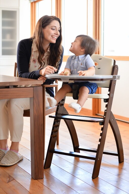baby in high chair smiling at his mom
