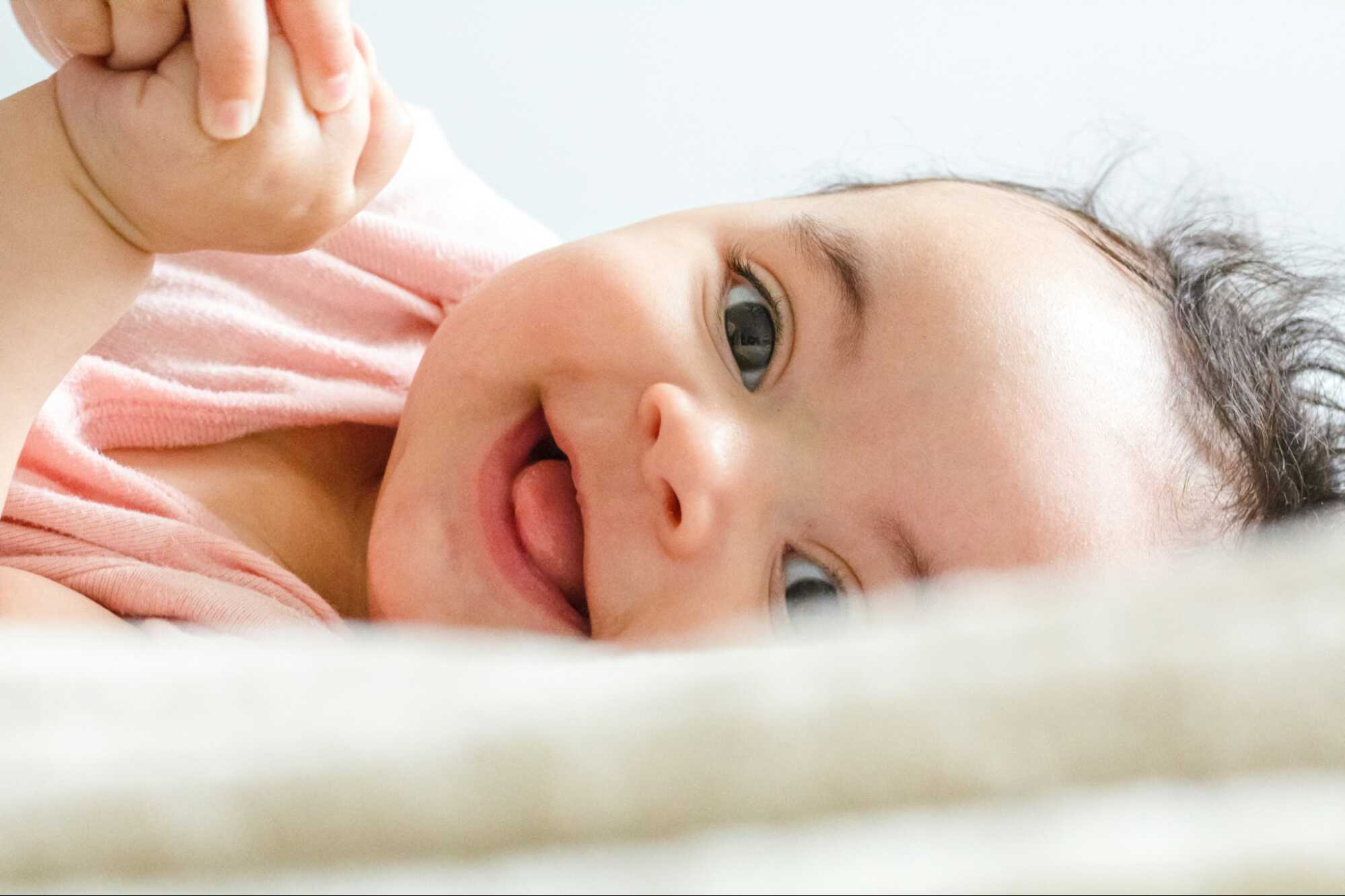 A baby lying on white textile