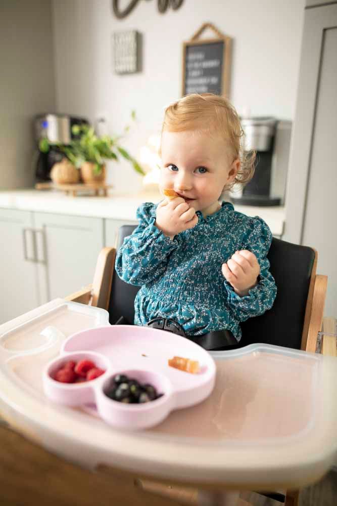 young child eating in a beyond junior y chair from an octopod dish