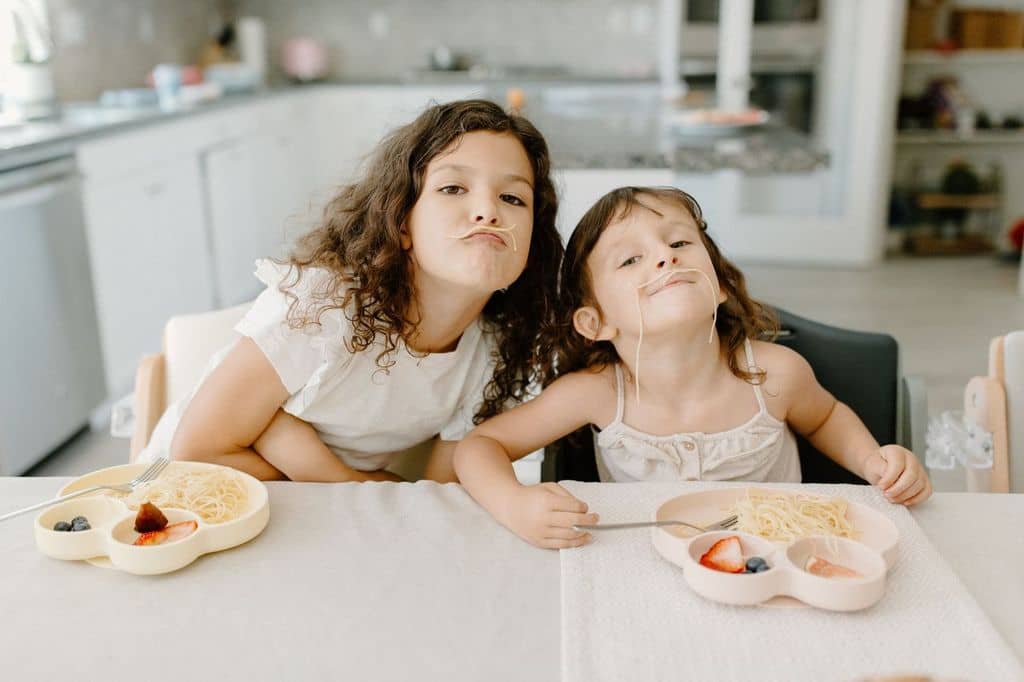 Kids eating pasta and fruit