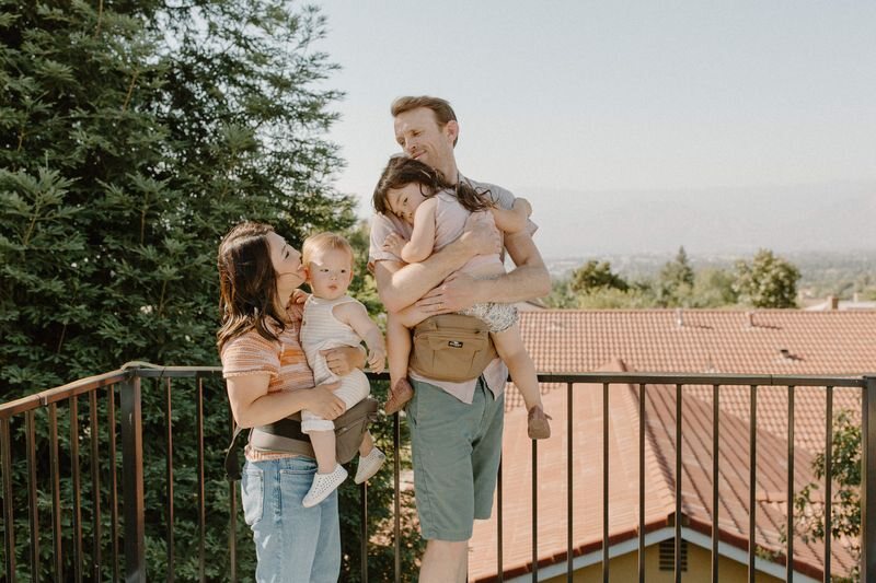Parents using buckle-based hip carriers